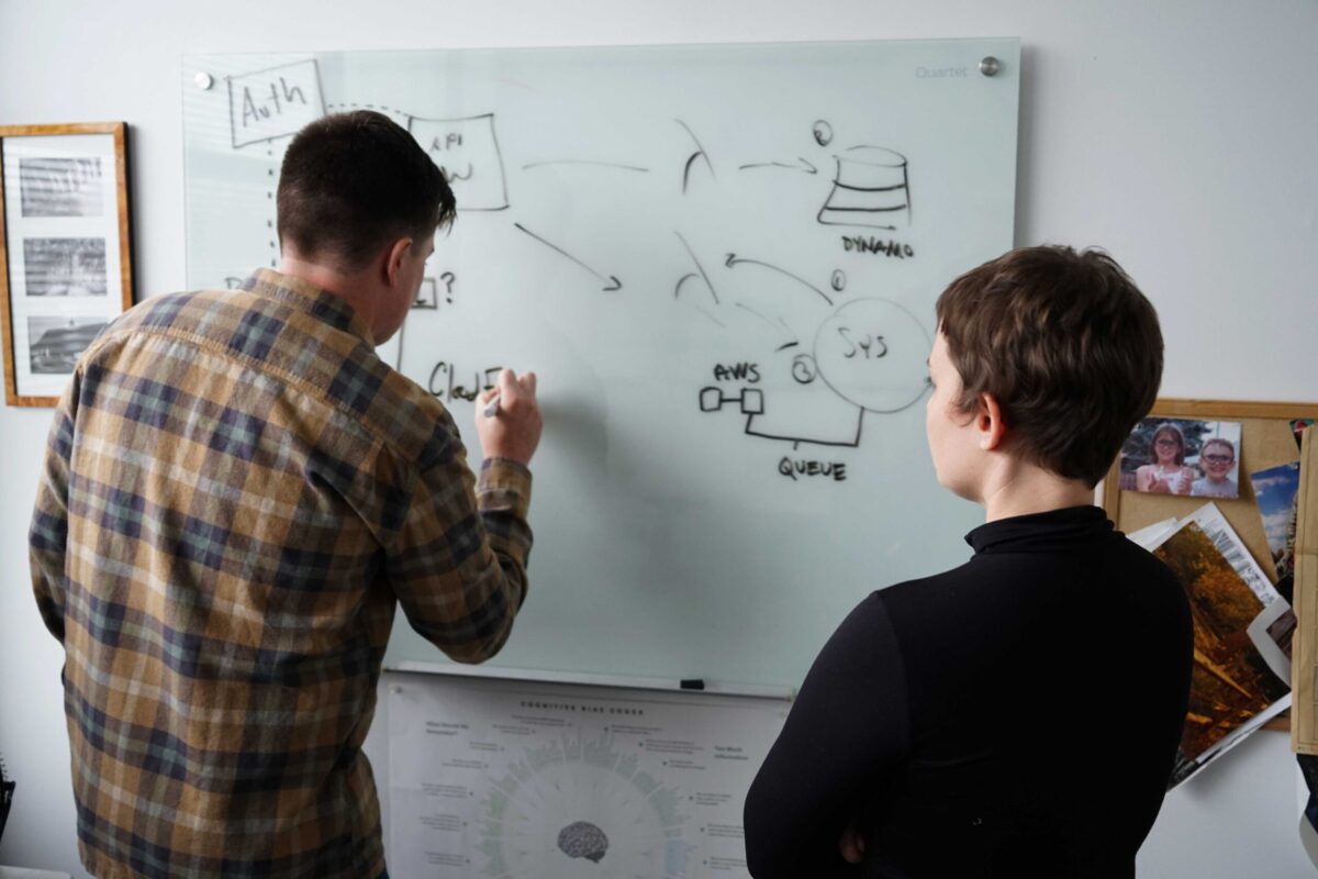 Photo of two technologists whiteboarding.