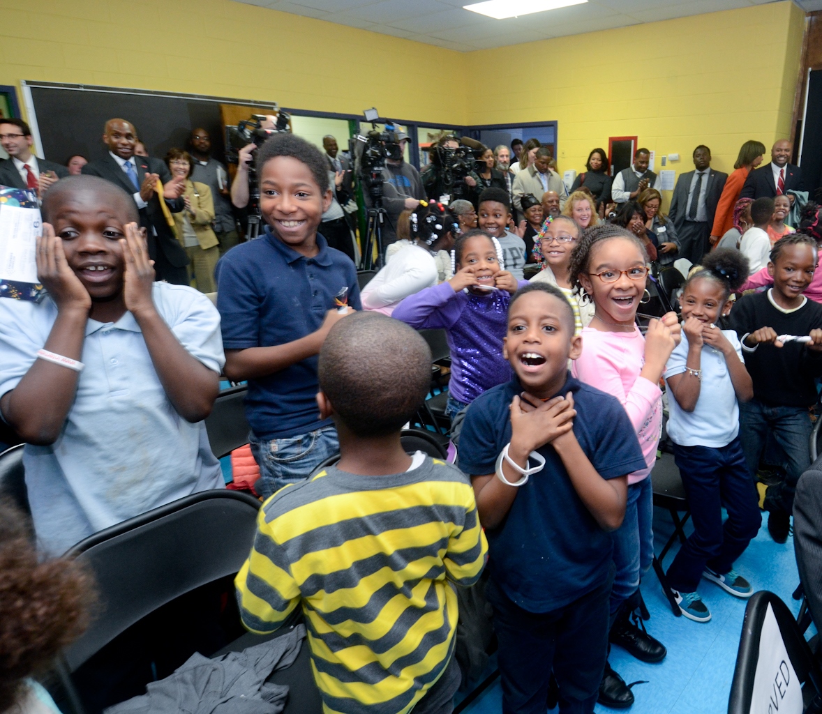 Students react to receiving free computers announcement at Internet Essentials event.