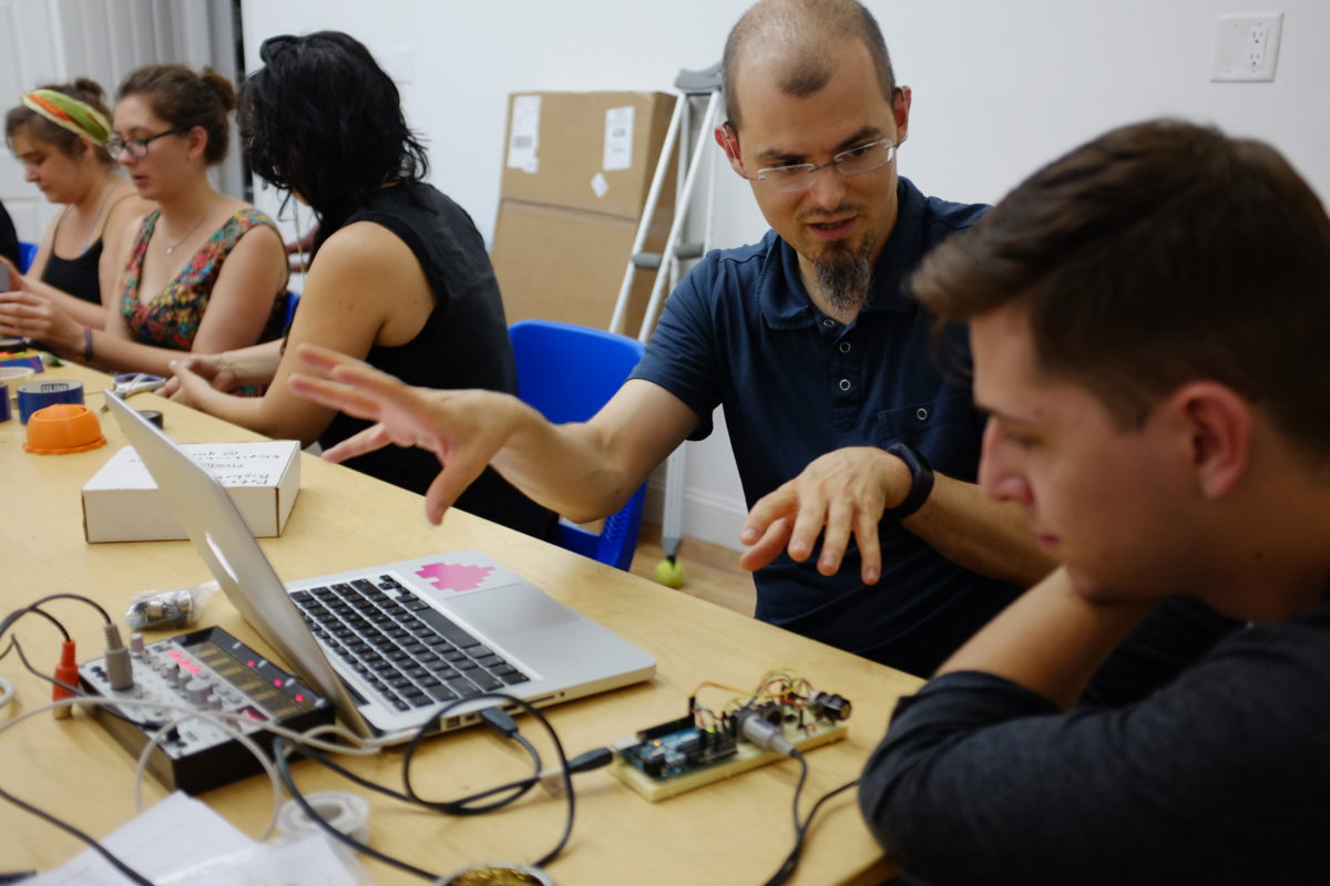 A picture of an instructor explaining the makings of a gadget inside The Hacktory.