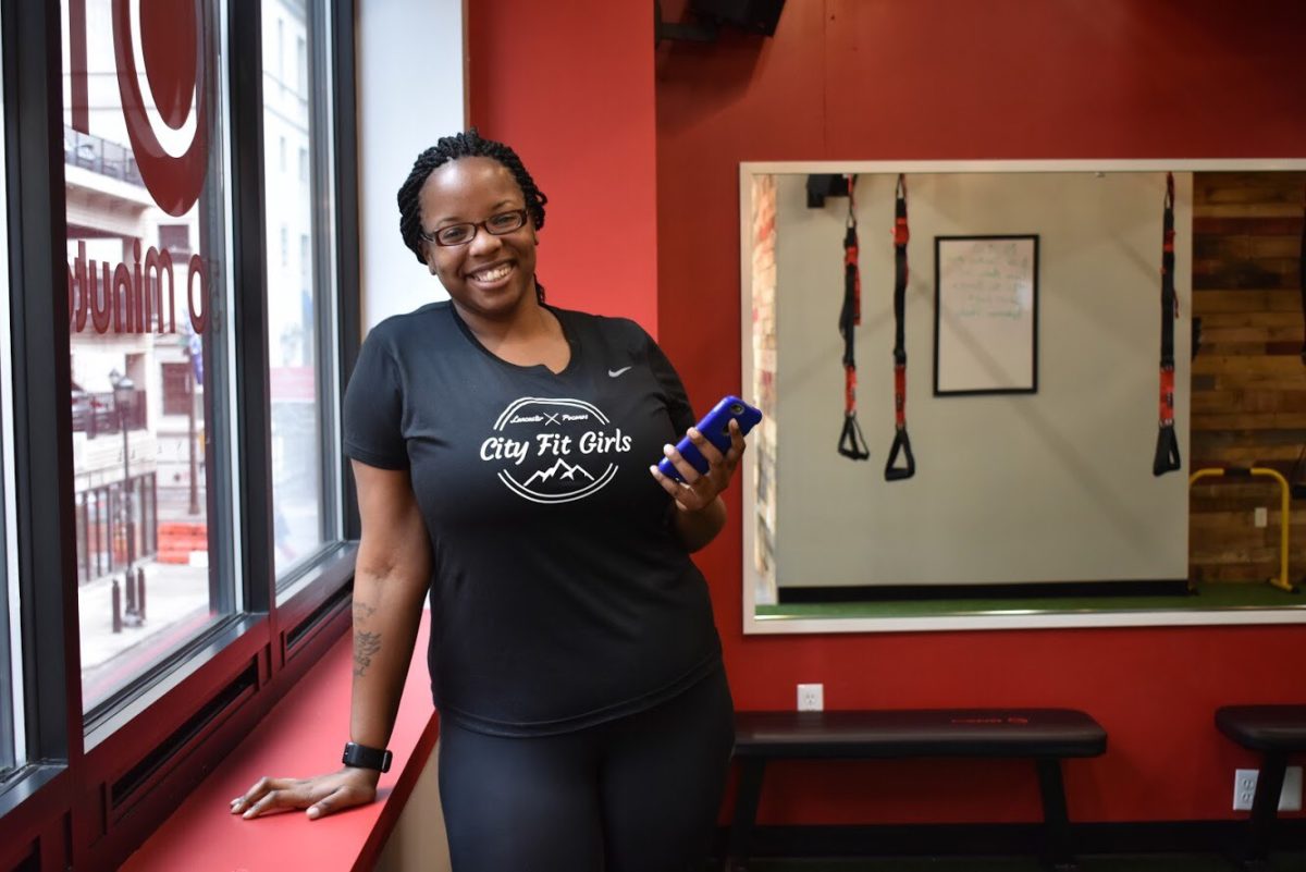 Kiera Smalls standing in a gym with red walls.