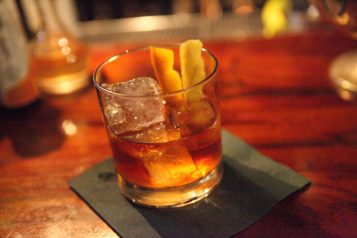 An old-fashioned in a warmly lit bar.