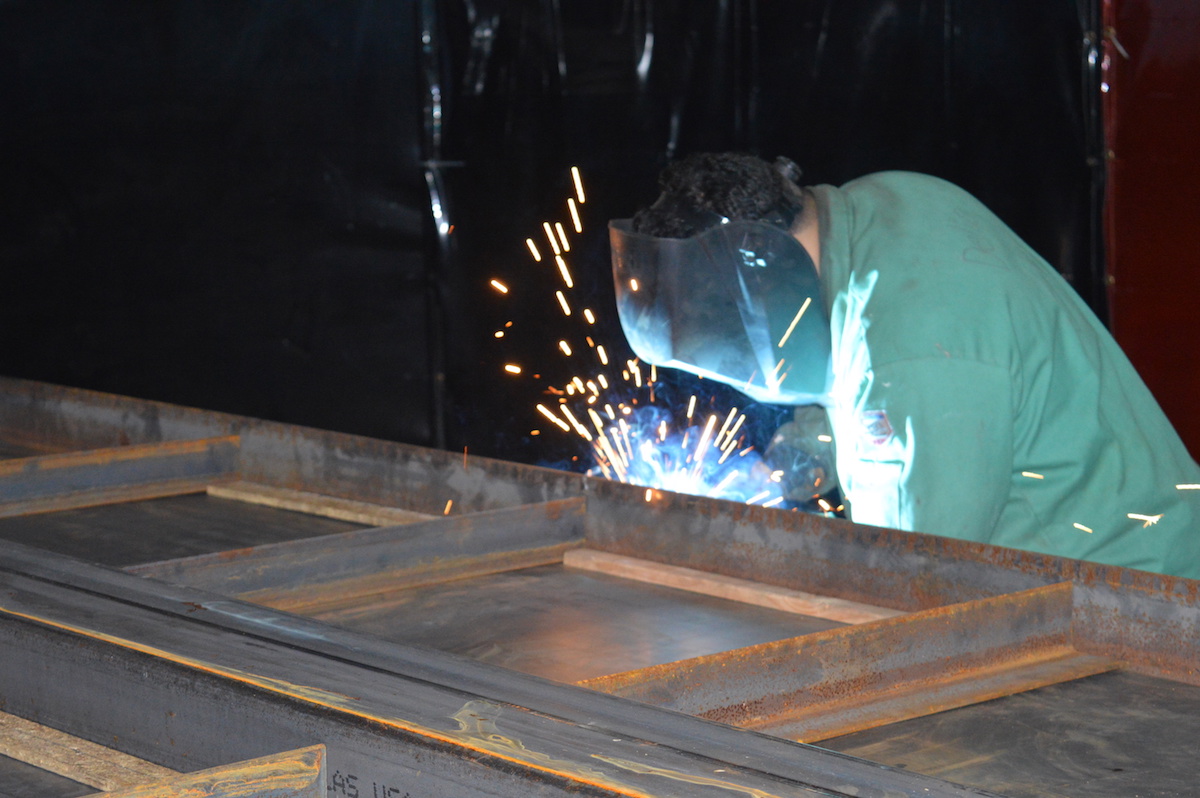 A Full Stack Modular worker welds the steel frame of one of the company's housing units.