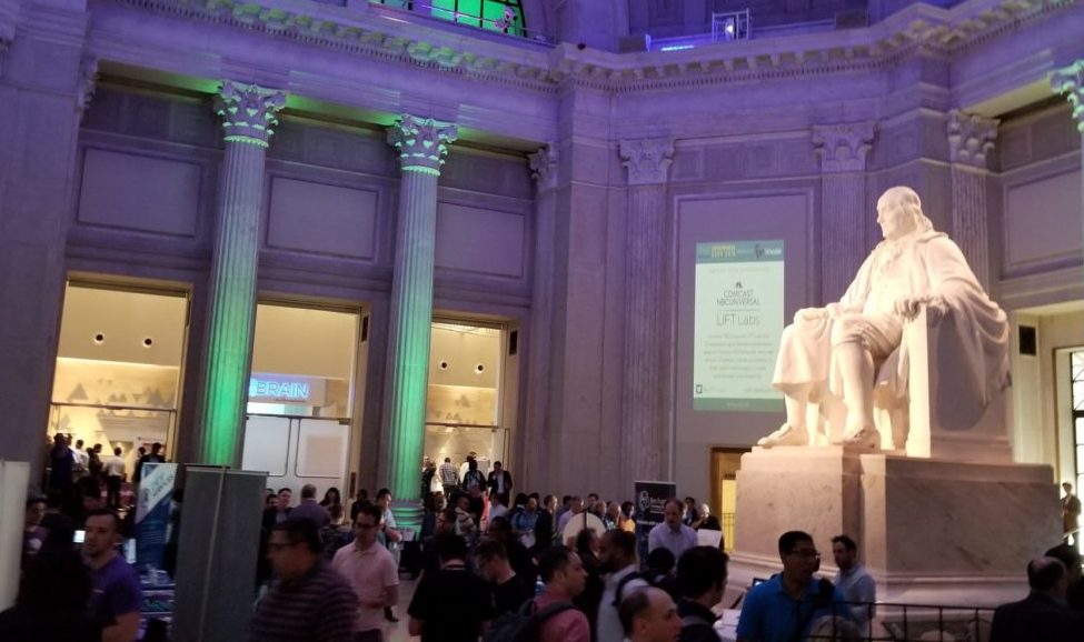 A giant statue of Ben Franklin surrounded by a crowd.