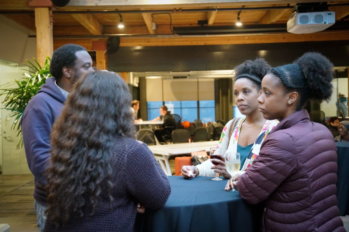Four founders standing around a table.