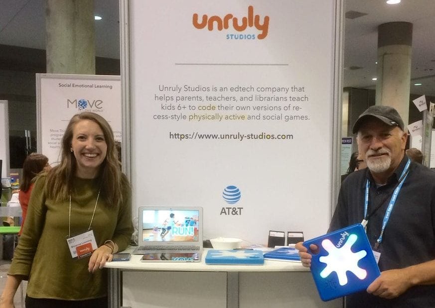 Two employees at a trade show booth.