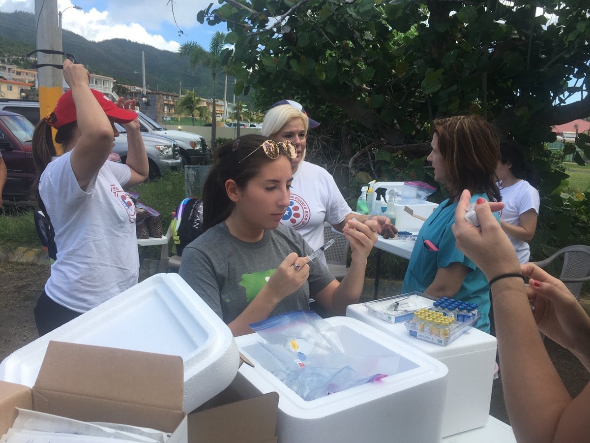 A volunteer uses a syringe