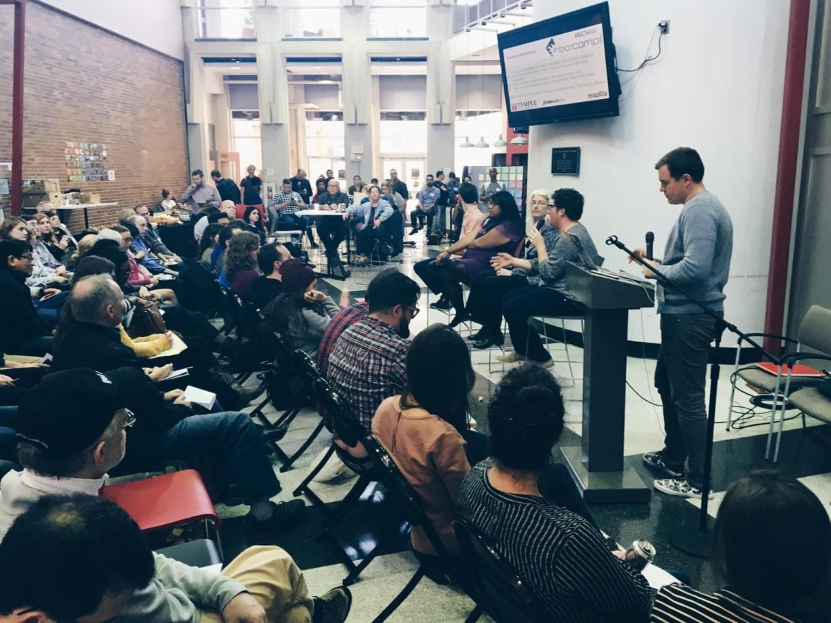 Photo of attendees seated and looking at a panel of seated experts