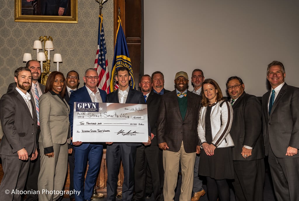 A group of people behind a big cardboard check.