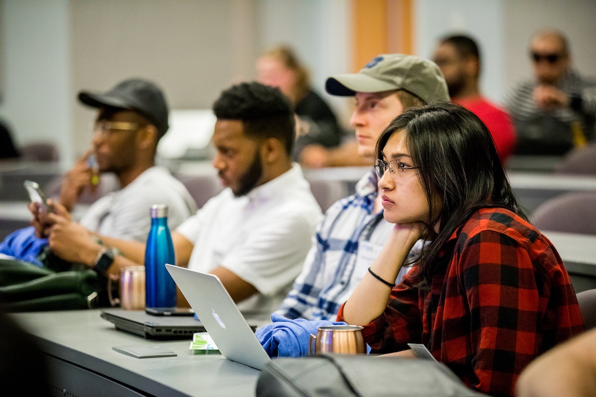 Technologists listen to a presenter