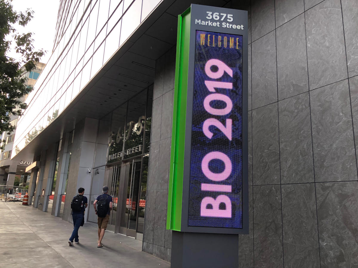 A screen in front of a University City building reads "BIO 2019"