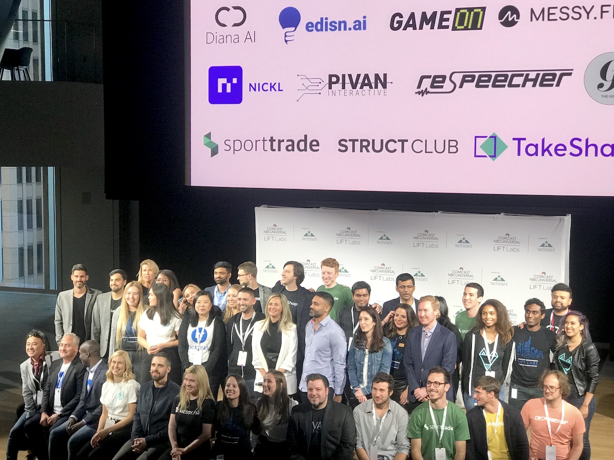 Accelerator participants stand on a stage