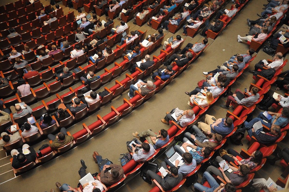 People sitting in auditorium chairs