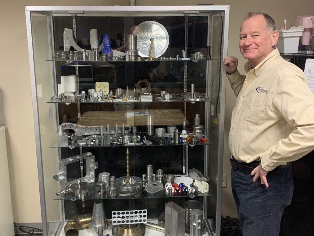Allied Precision owner John Lees displays some of the many parts the company has manufactured over the years.