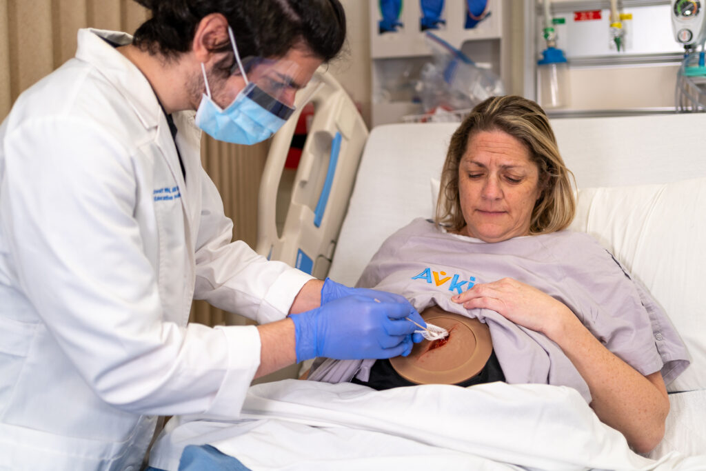 Avkin An actor wearing a simulated wound device is assesed by a healthcare student.