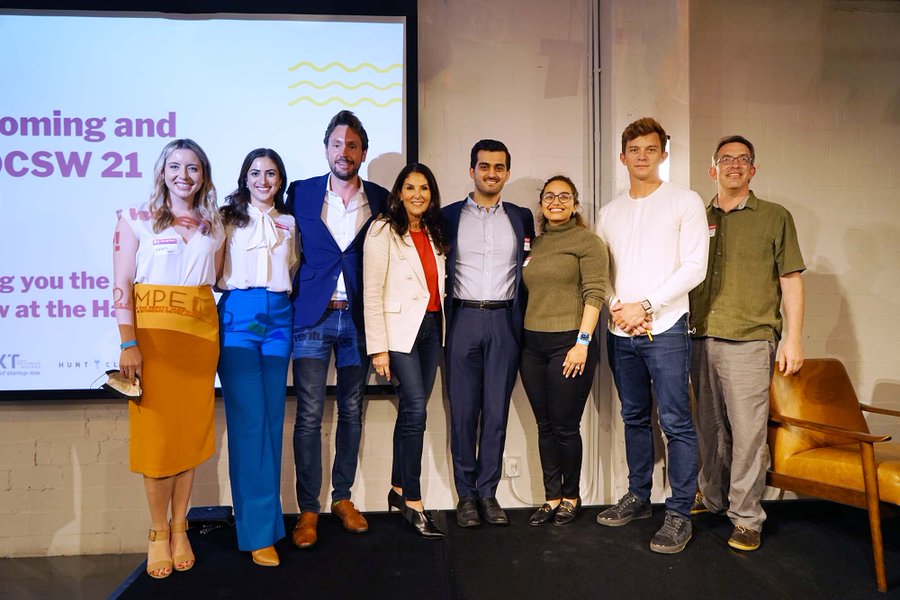 Several DC-area founders pose in white and green shirts and blue and orange dress clothes