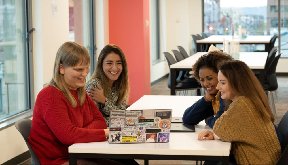 A group of 4 Ada Developer Academy students around a laptop