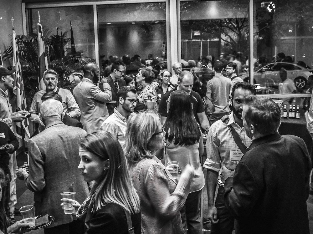 Black-and-white image of crowd in room during event.