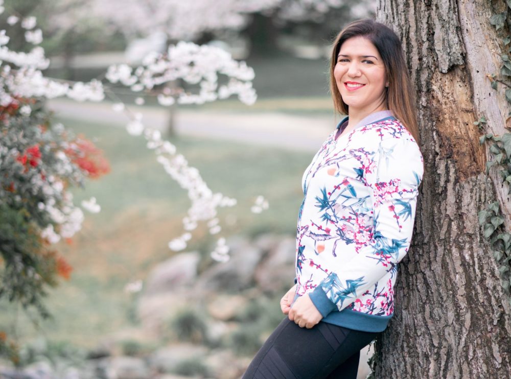 Lauren Maffeo poses beside a tree