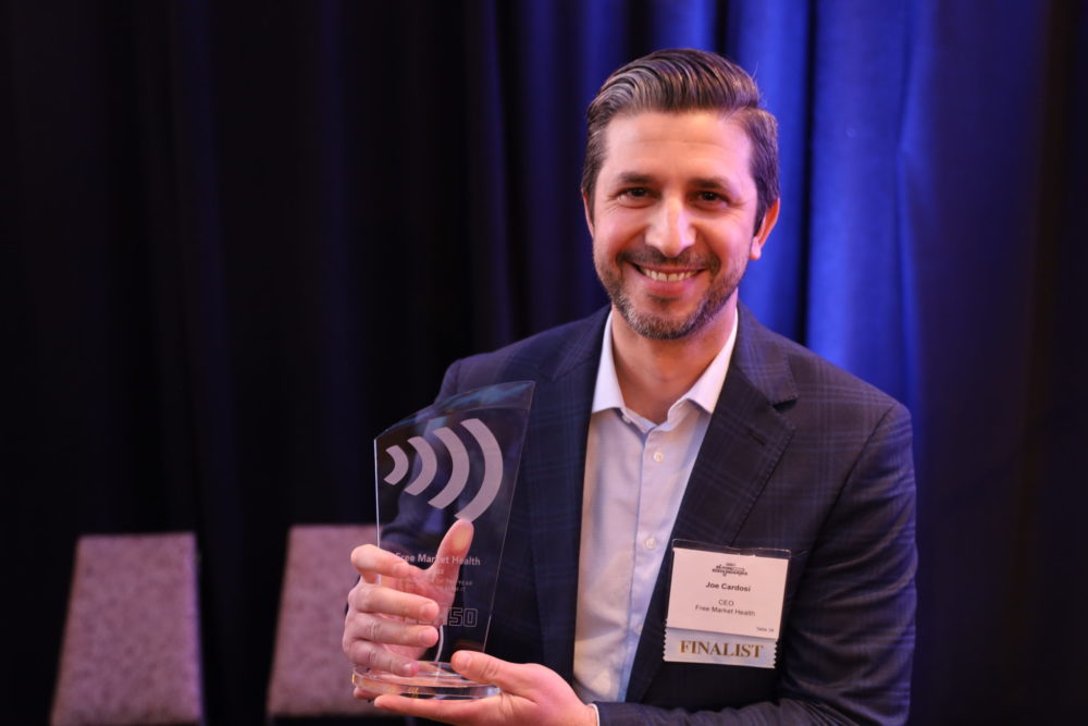 A man in a suit holding an award.