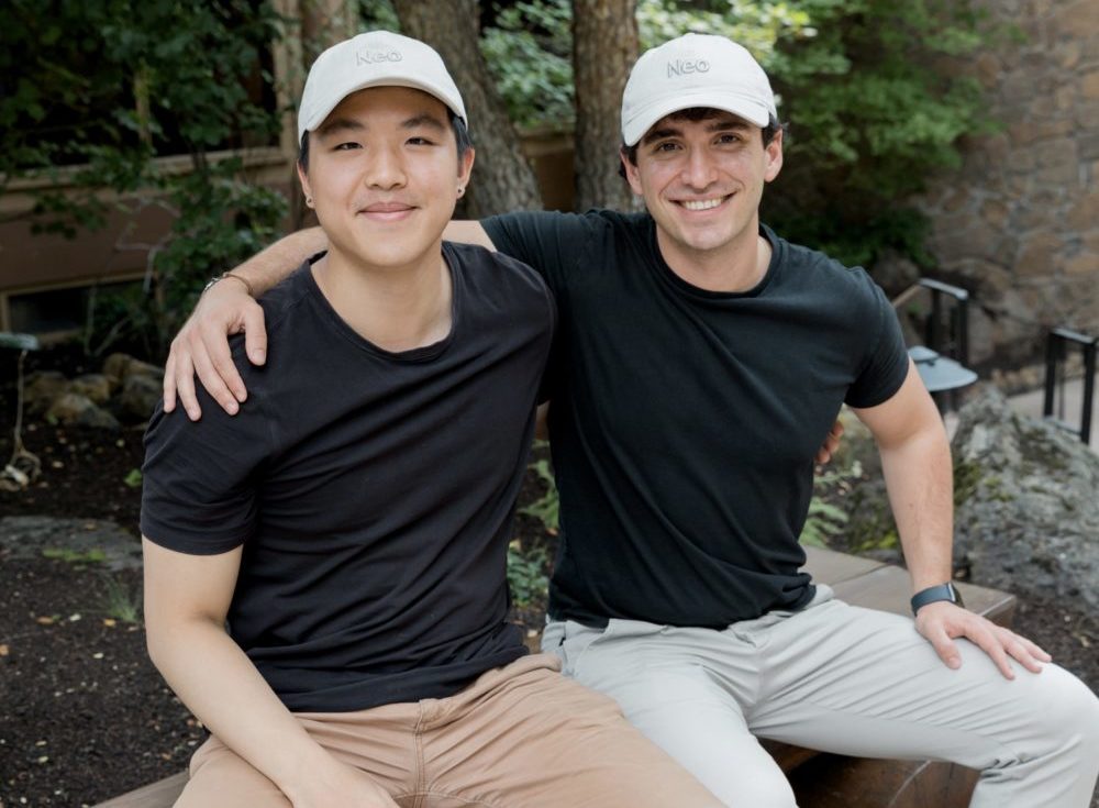 Chestr's founders sit in matching black shirts and hats featuring the company logo.