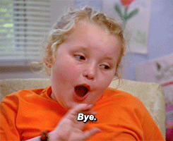 A young blonde girl sassily saying "Bye" and waving.