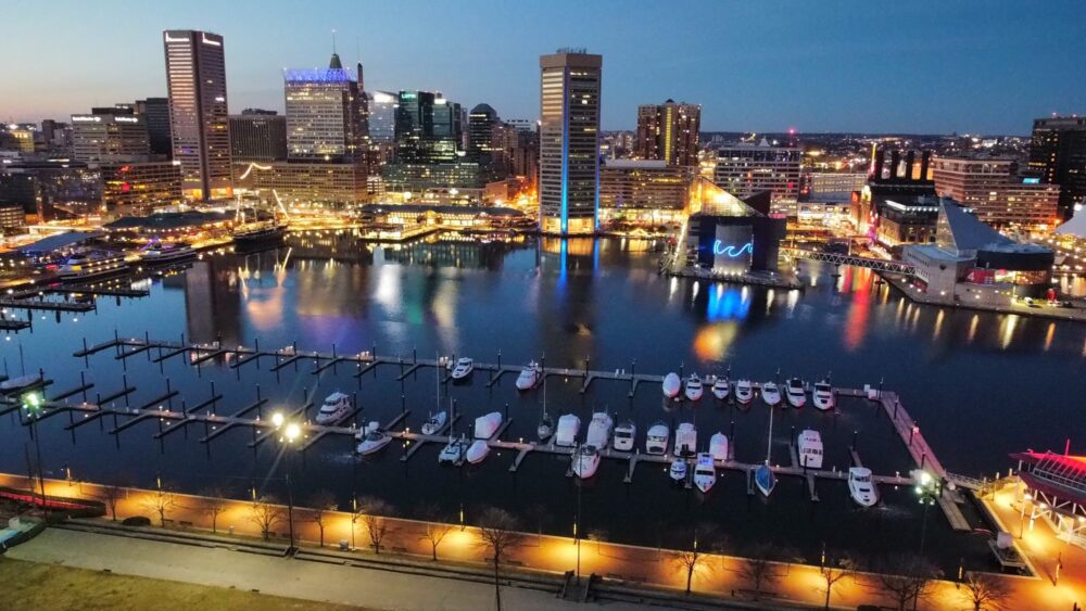 Baltimore skyline before harbor reflecting yellow lights and blue and pink sky