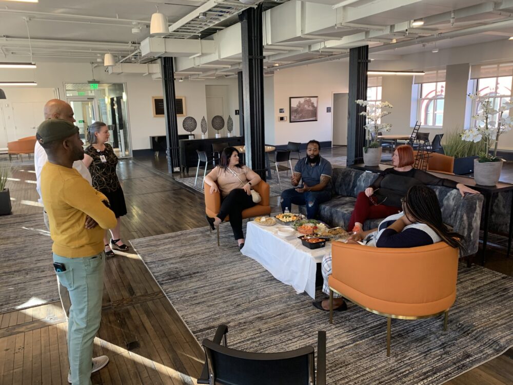 A group of people sitting on couches talking.