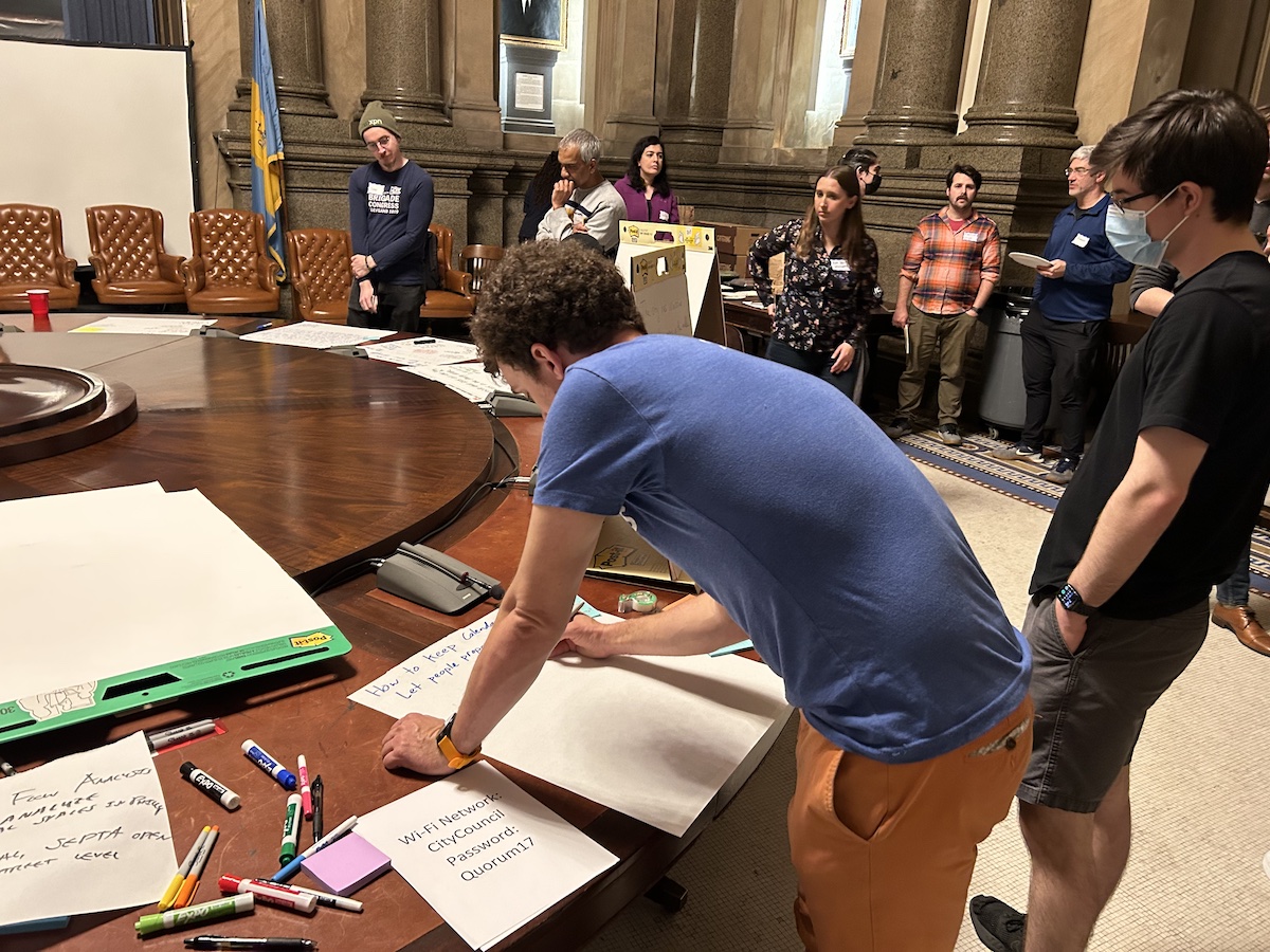 Group of people attending a workshop with one person writing on a flip chart.