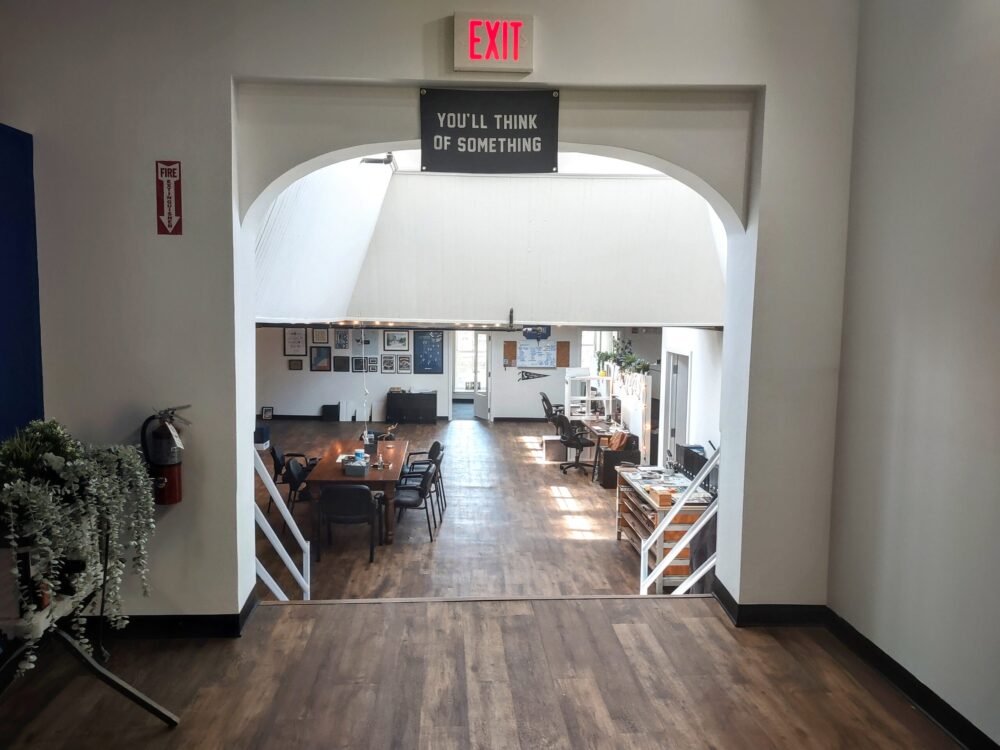 Interior of a modern cafe with an archway entrance and inspirational signage above.