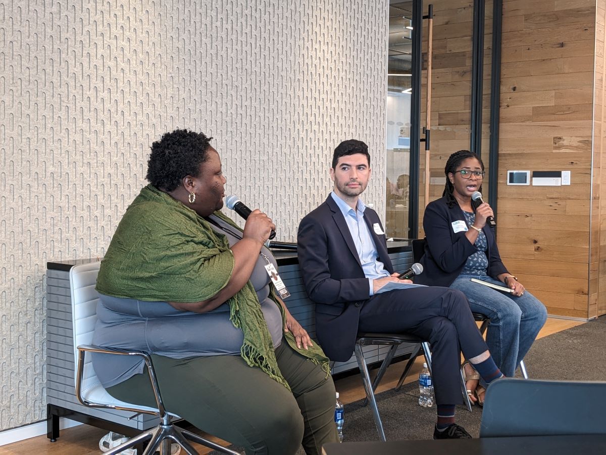 Three professionals participating in a panel discussion indoors.