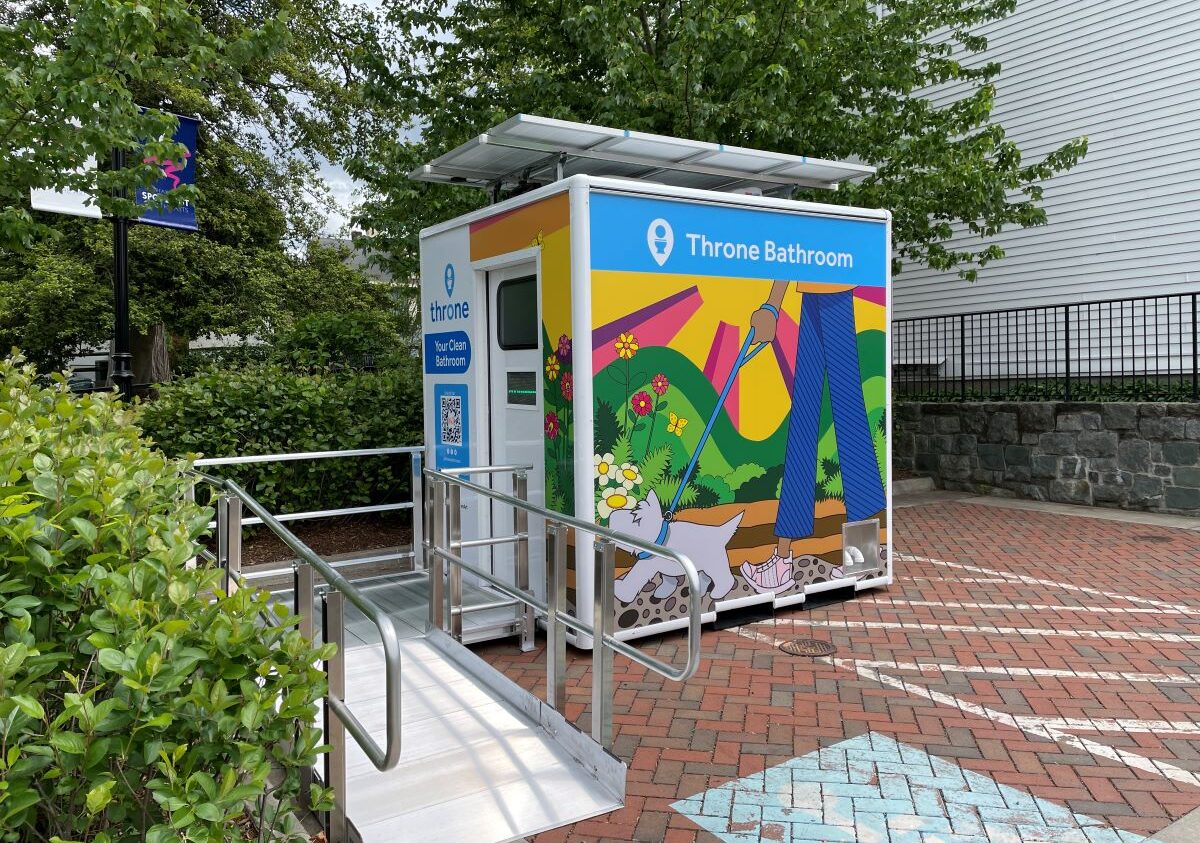 Public restroom facility with colorful graphics located in an outdoor setting with a ramp for accessibility.