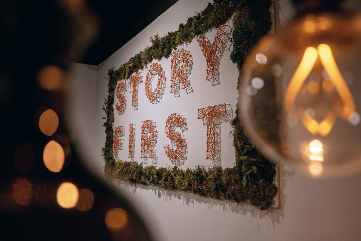 A framed art piece that says "STORY FIRST."