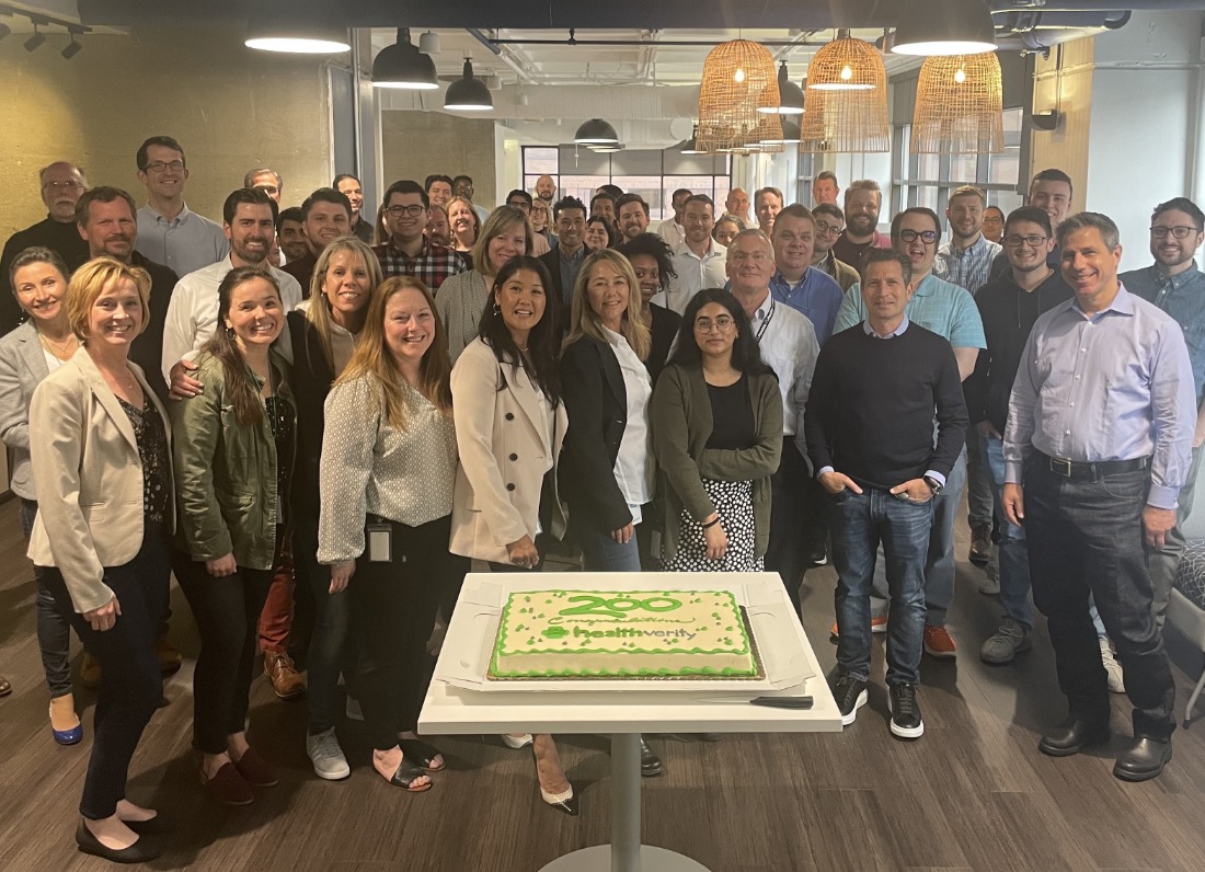 Group photo of the HealthVerity team standing behind a cake.