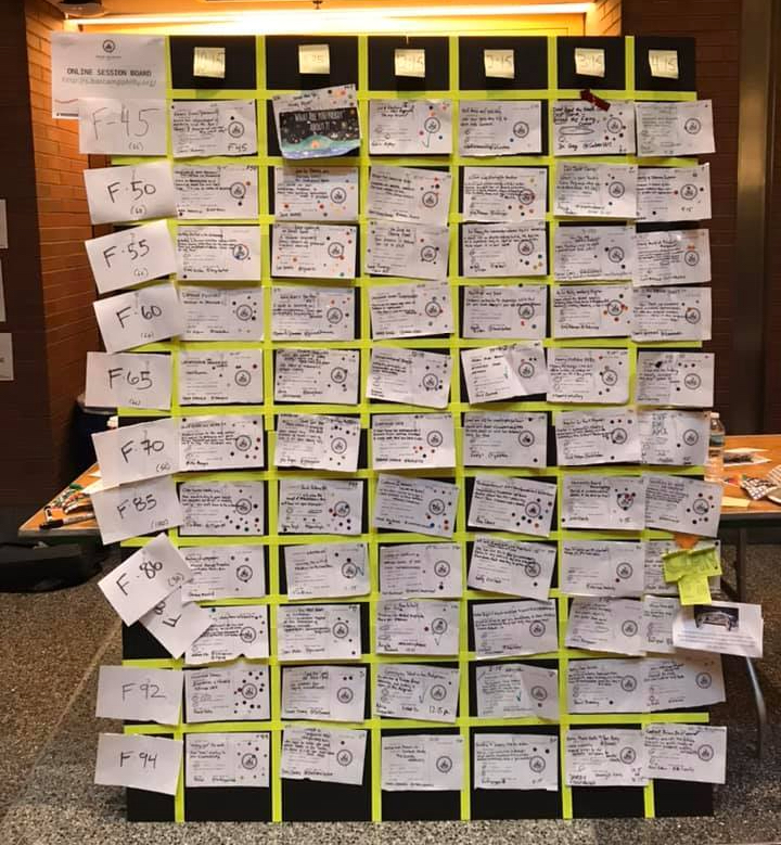 Handwritten cards arranged in rows on a large standing board.
