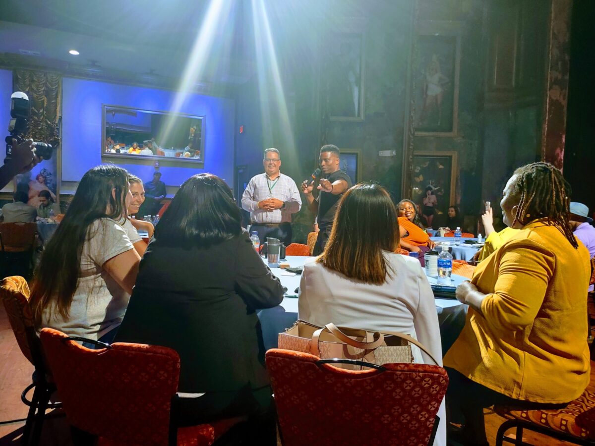 A group of people sitting around a table in a room.