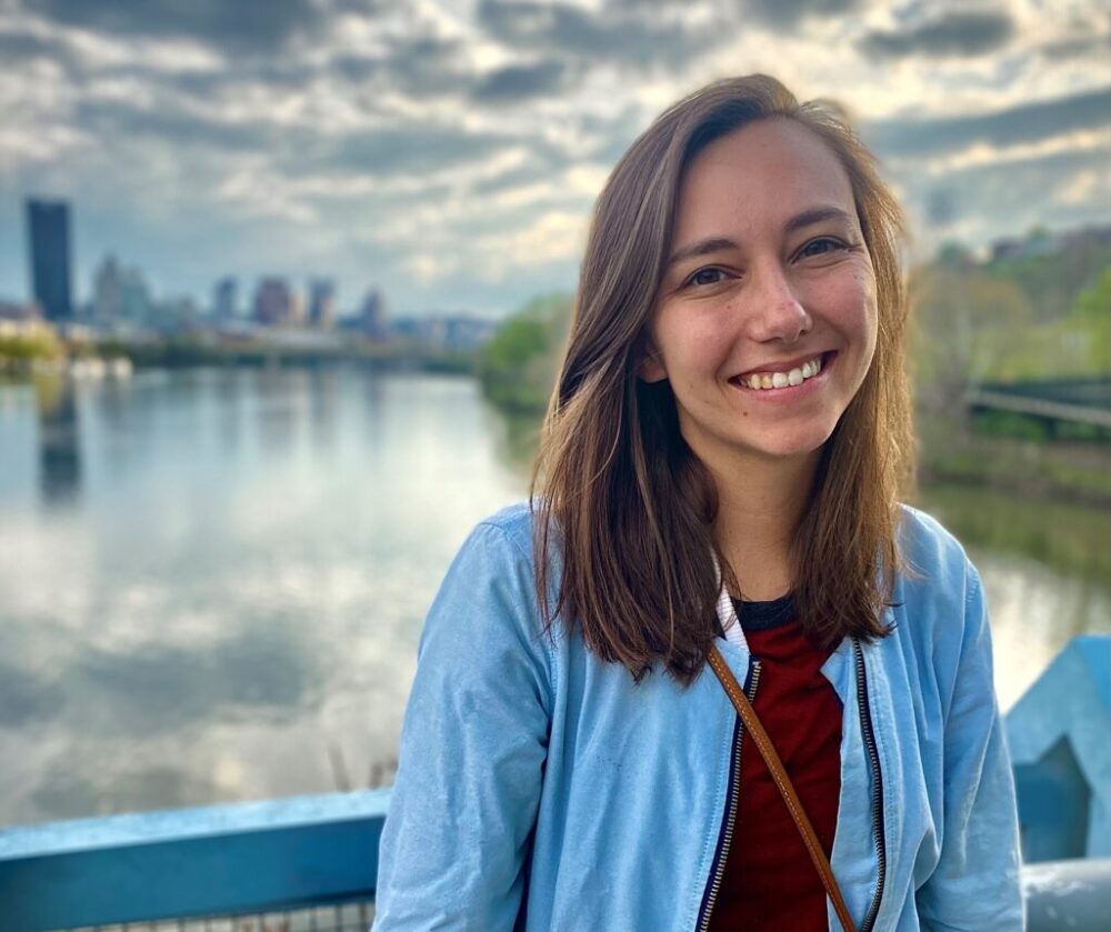A woman smiling at camera in Pittsburgh.
