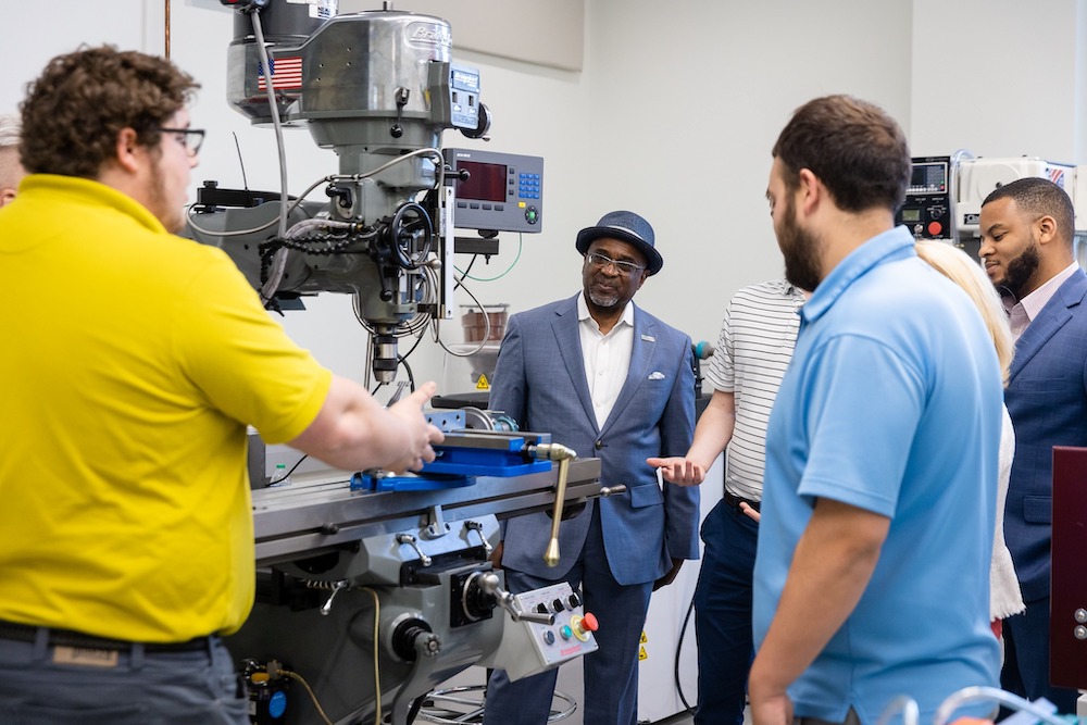 A group of people standing around a machine.