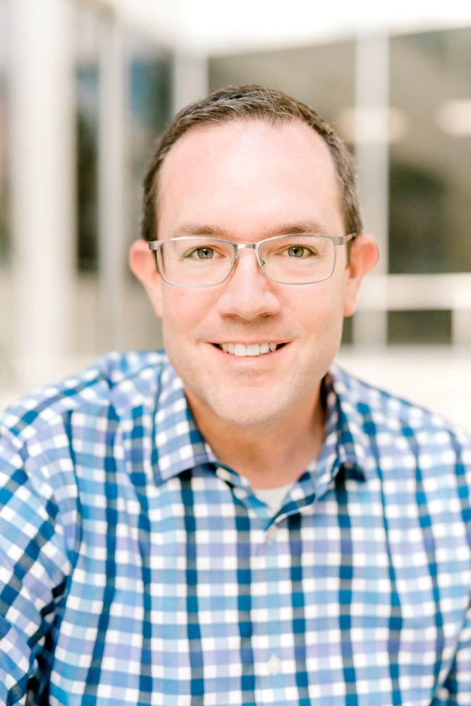 A man wearing glasses and a plaid shirt.
