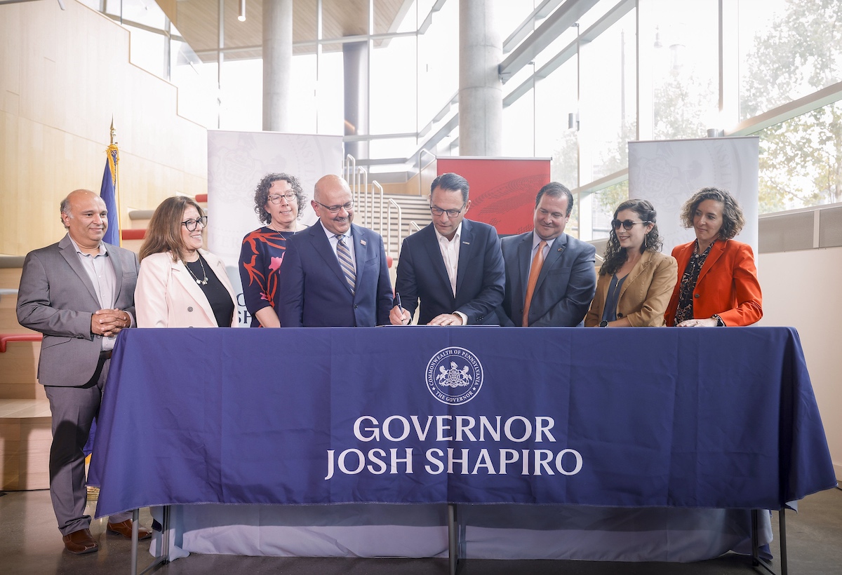 A group of people standing around a table with a sign that says governor josh shapiro.