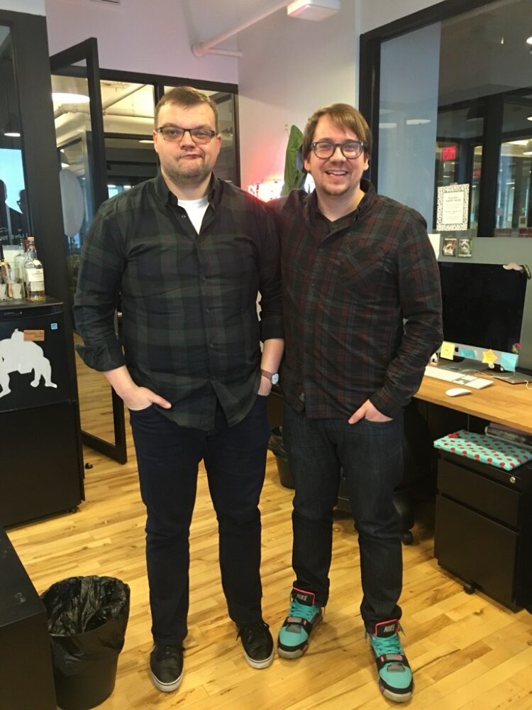 Two men standing next to each other in an office.
