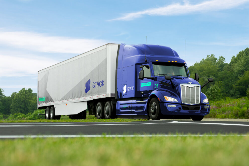 A blue semi truck driving down the road.