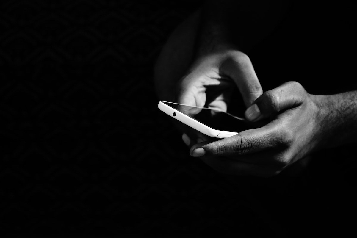 A black and white photo of a person holding a cell phone.
