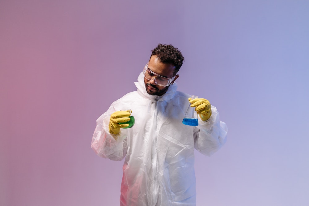A man in a lab coat holding a test tube.