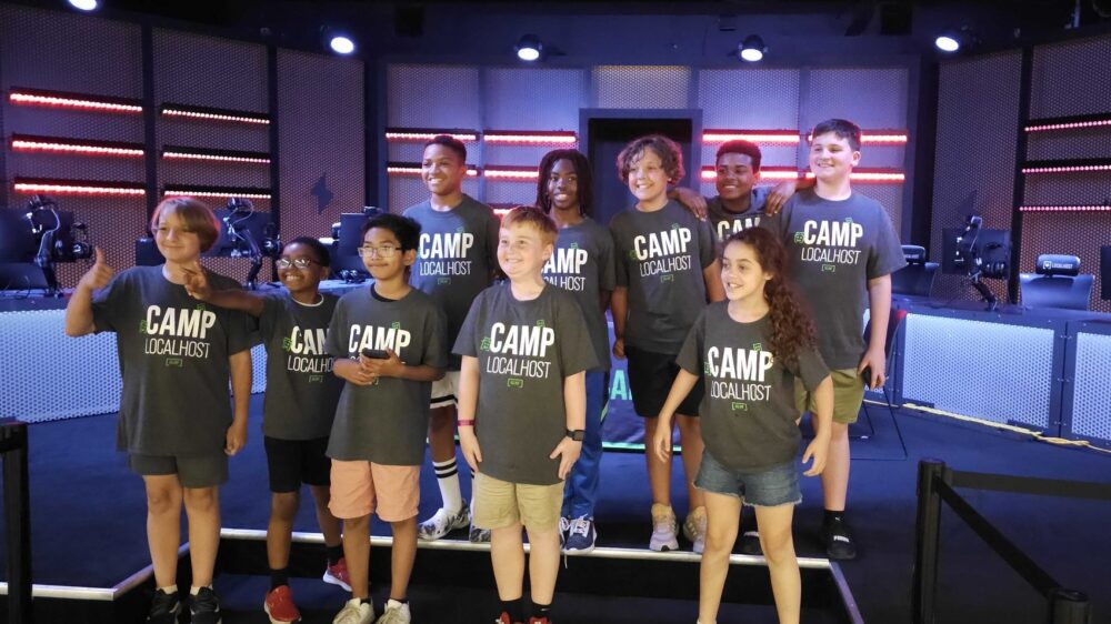 A group of kids standing in front of a stage.