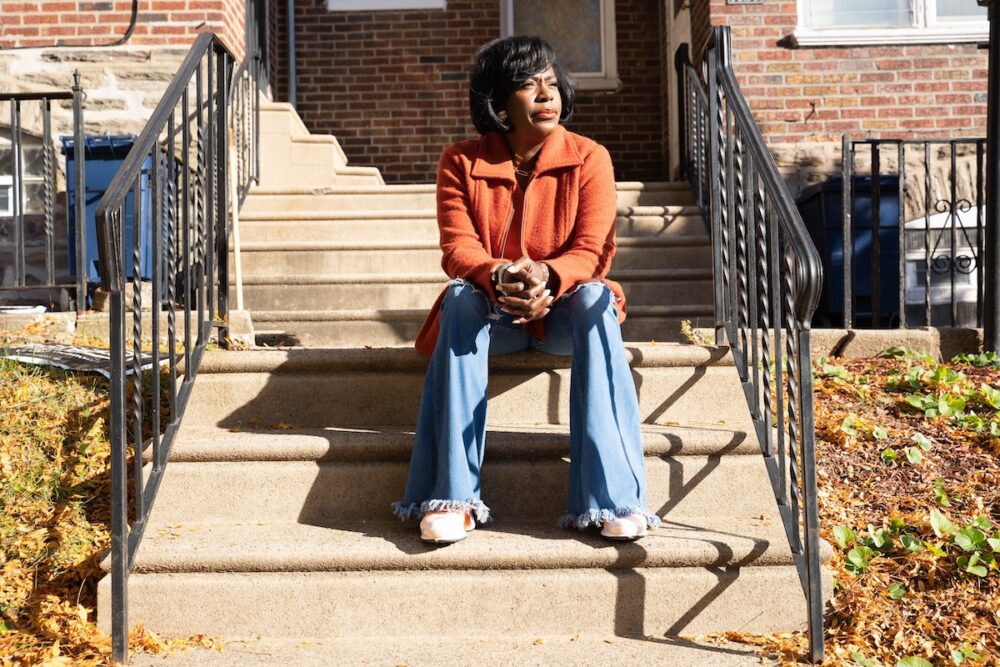 A woman sitting on the steps of a house.