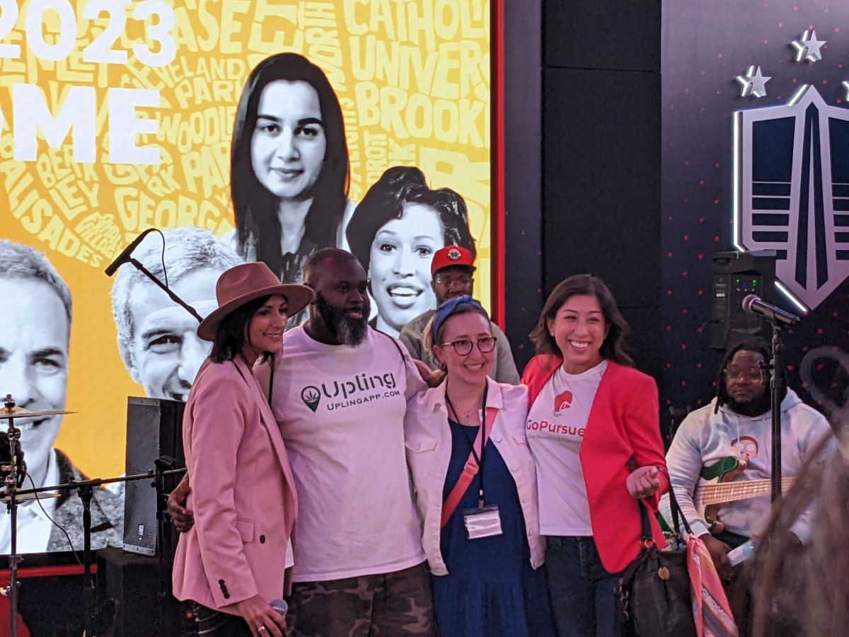 A group of people standing in front of a large screen.