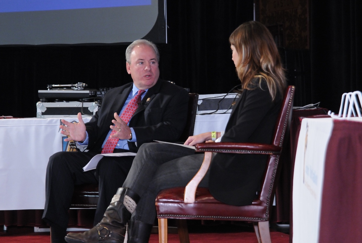 A man sitting in a chair talking to a woman.