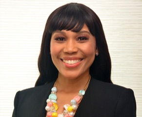 A woman wearing a black jacket and a colorful necklace.
