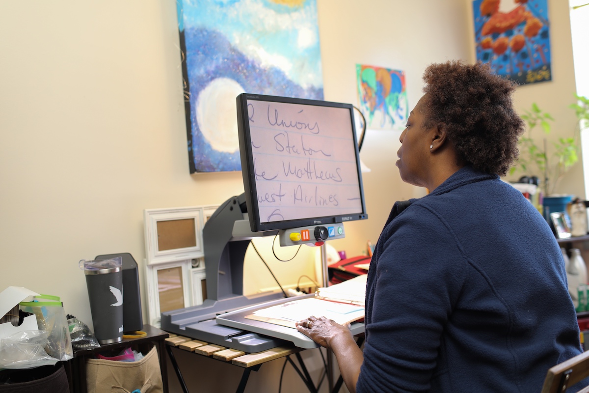 A woman works on a computer with magnified text.