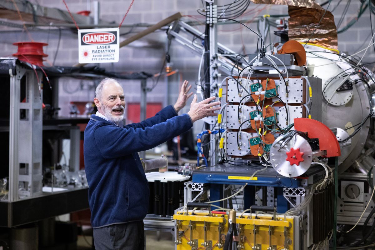 A man standing in front of a machine in a factory.